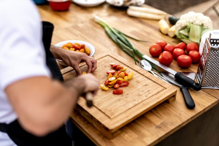 A person preparing vegetables on a cutting board