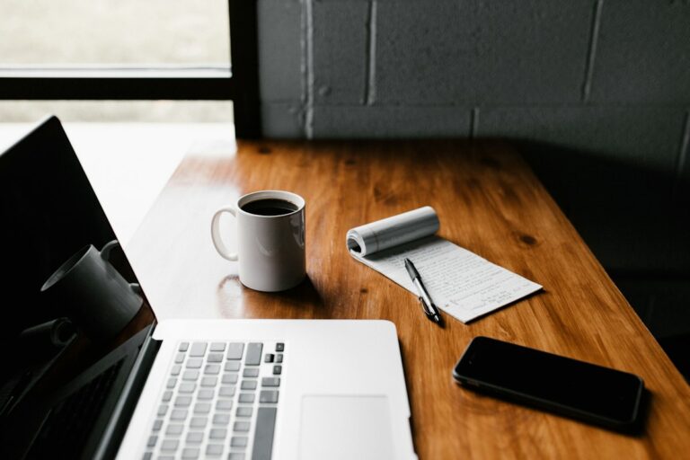 A laptop and coffee on a wooden desk