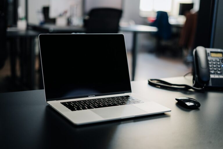 An open laptop on a dark desk